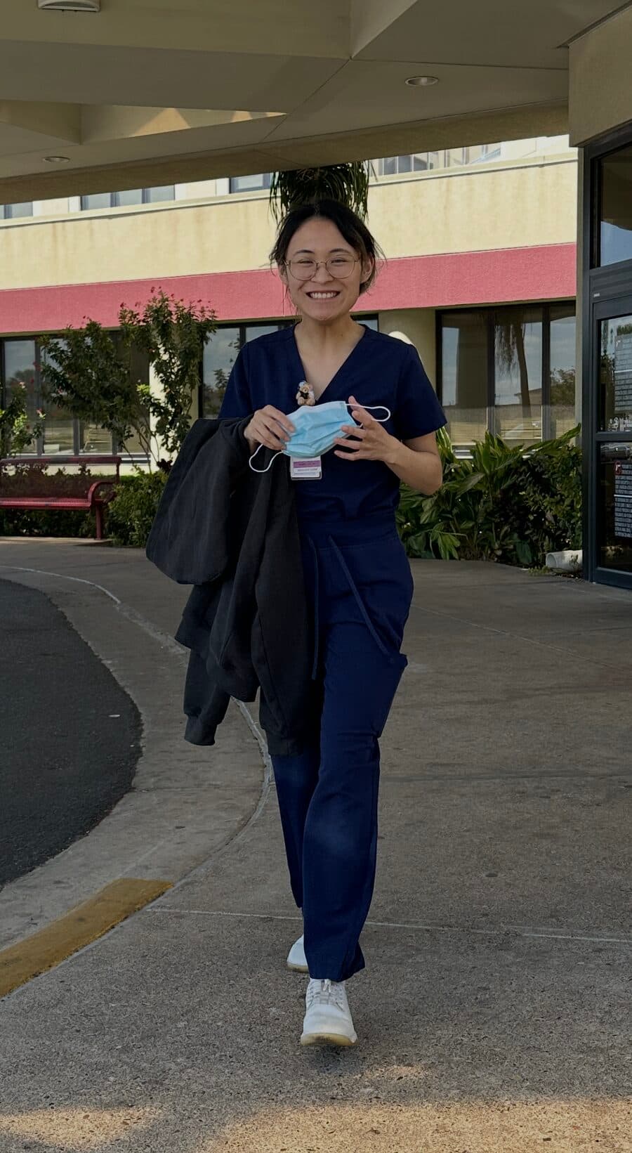Ysabella in navy scrubs, smiling, heading in to a shift at Mission Regional Medical Center